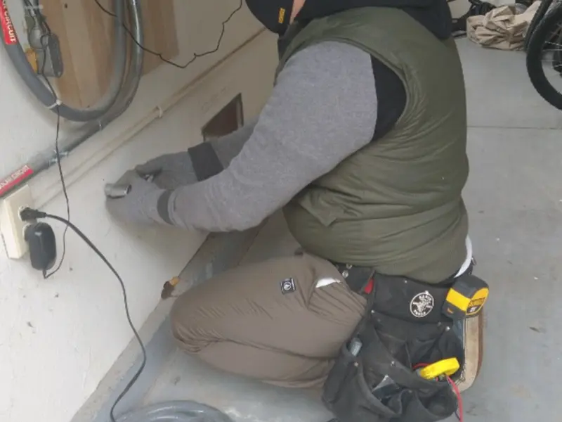 Electrician performing outlet wiring in a Winslow garage